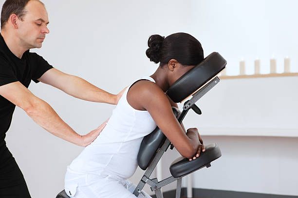 Massage Amma Assis en entreprise - collaborateur sur chaise ergonomique recevant un massage du dos